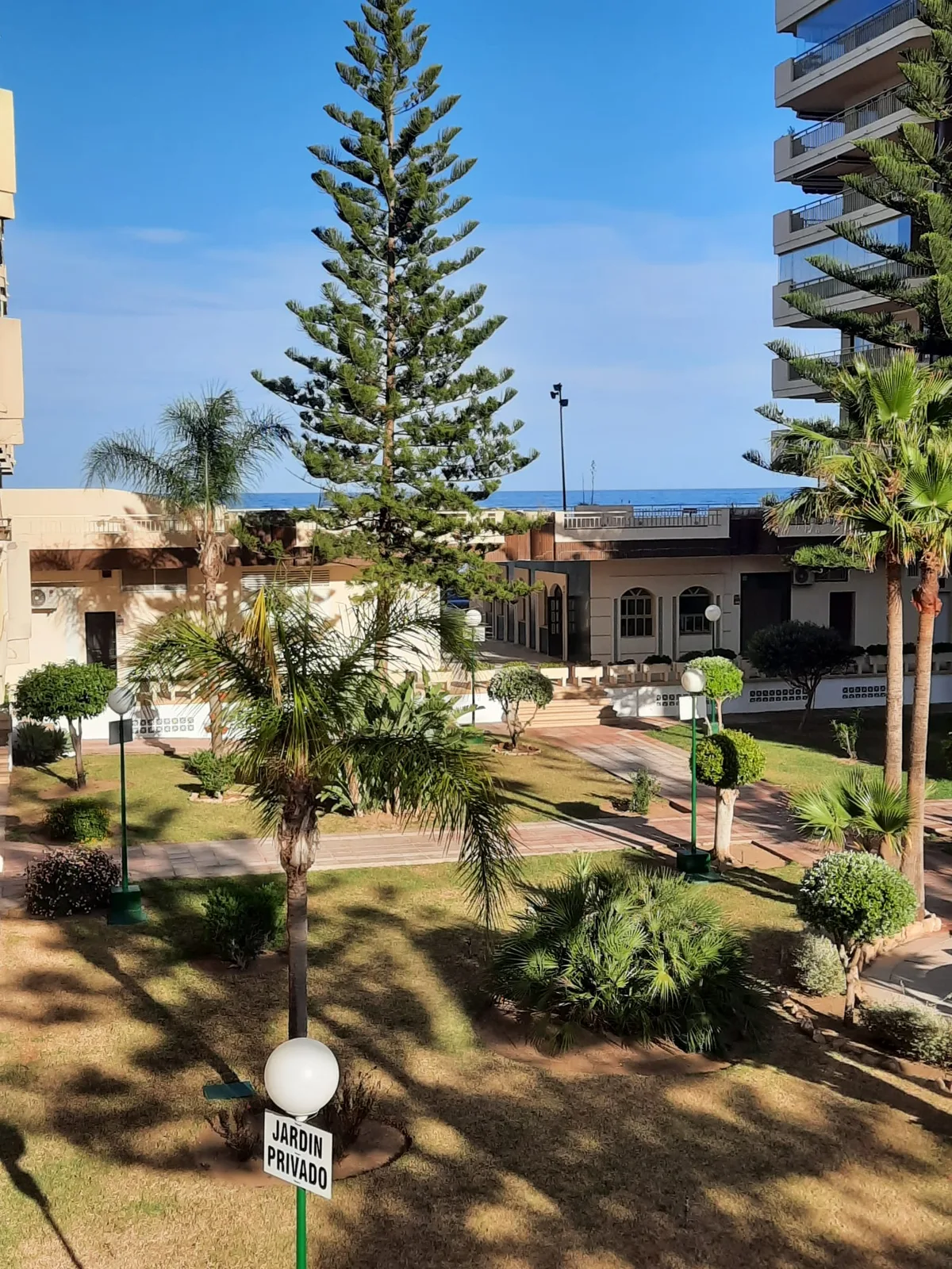 Privétuin van het complex met uitzicht op zee